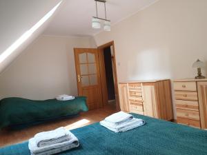 a bedroom with two beds and a dresser at Onufrowy Dworek in Ruciane-Nida