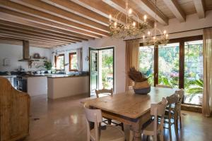 una cucina e una sala da pranzo con tavolo e sedie in legno di B&B Maison Parco Del Brenta a Curtarolo