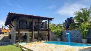 a villa with a swimming pool and a house at EnseadaPrime hospedagem beira-mar na Praia Enseada dos Corais em PE in Cabo de Santo Agostinho