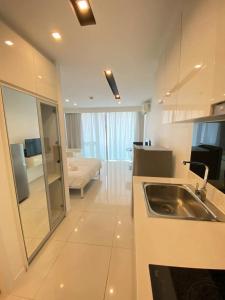 een keuken met een wastafel en een woonkamer bij City Center Residence Kim in Pattaya