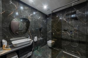 uma casa de banho com um lavatório e um chuveiro em Hotel ZEMPLEN em Michalovce