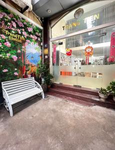 a white bench sitting outside of a store window at TrangTien Hostel in Hanoi