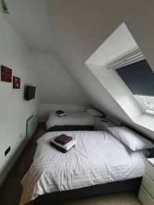 a attic bedroom with two beds and a window at Fort William Lovely Flat Central location in Fort William