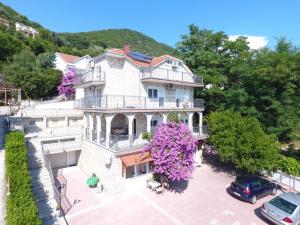 an aerial view of a large white house with purple flowers at Vila Ćorović in Kumbor