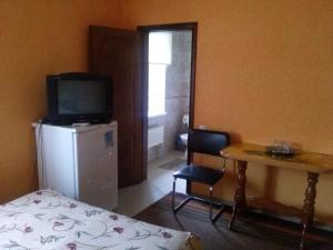 a room with a refrigerator and a table with a television at Hotel Kiev-S in Zhashkiv