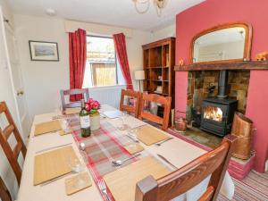 a dining room with a table and a fireplace at 1 Pennine View in Long Marton