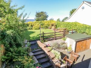 a garden with a wooden fence and a playground at 1 Pennine View in Long Marton