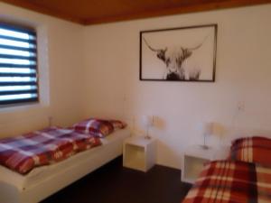 a bedroom with two beds and a picture of a cow at Holzhaus Fechheim in Neustadt bei Coburg