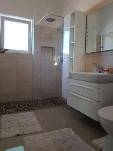 y baño con ducha, lavabo y aseo. en Apartman Ana, en Dobropoljana