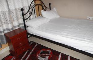 Snow Valley Cottages في كاسيزي: غرفة نوم مع سرير وخزانة وسرير سيد