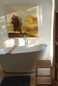 a bath tub in a bathroom with a painting on the wall at Ferienwohnung Jeannette I in Hasselfelde