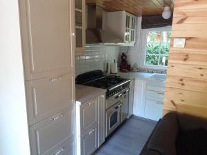 een keuken met witte kasten en een fornuis met oven bij Vakantiehuisje in Lanaken