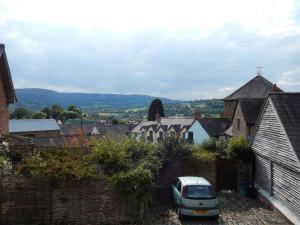 克里克豪厄爾的住宿－The Studio, Upper House Farm, Crickhowell.，停放在有房屋的小城镇的汽车