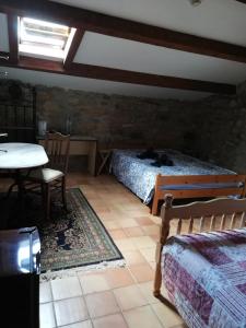 a bedroom with two beds and a table and a table and chairs at Ardèche chambres d hôtes près de Vallon pont d Arc in Grospierres