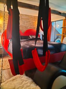 a swing bed in a room with a bed at Love room, L'idyle loft érotique détente in Callac