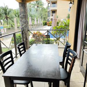 een tafel en stoelen op een balkon met uitzicht op het strand bij BEACHFRONT Condo Bahia Encantada Jaco Beach L1 in Jacó