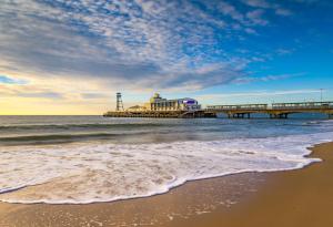 a pier on the beach next to the ocean at The Hermitage Hotel - OCEANA COLLECTION in Bournemouth