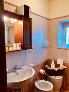 a bathroom with a sink and a toilet and a mirror at Casina di Rosa in Civitella Marittima