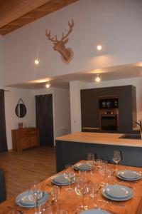 a dining table with wine glasses and a deer head on the wall at Chalet Alexanne - Meublé de tourisme classé 3 étoiles - Porte de St Gervais in Passy