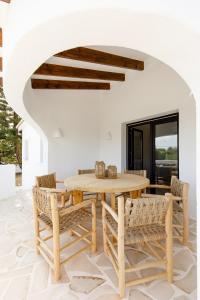 a dining room with a wooden table and chairs at CASA LUZ - Somewhere south villas by Astrid Elisee in Benitachell