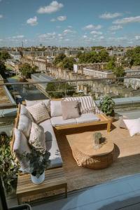 a balcony with a couch and a table and a city at Penthouse. Roof Terrace. Shoreditch. AC in London