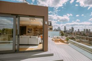 a house with a balcony with a view of the city at Penthouse. Roof Terrace. Shoreditch. AC in London