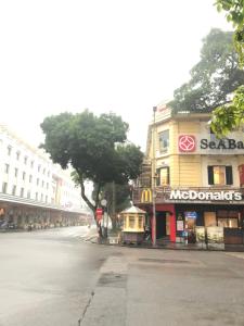 an empty street in a city with a mcdonalds building at TrangTien Hostel in Hanoi