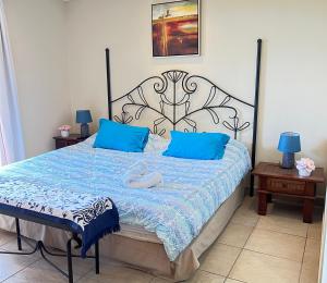 1 dormitorio con 1 cama grande con almohadas azules en BEACHFRONT Condo Bahia Encantada Jaco Beach L1, en Jacó