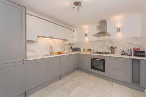 a large white kitchen with white cabinets and appliances at Crescent Mews in Bath