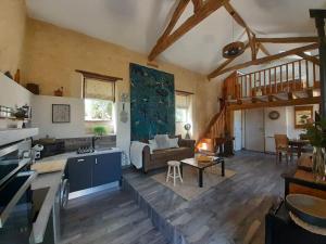 a kitchen and living room with a couch and a table at Le Petit Coin - LPC Dordogne Holidays in Lussas-et-Nontronneau