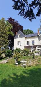 une maison blanche avec des tables et des chaises dans la cour dans l'établissement VILLA NOTRE DAME face au Château fort, à Sedan