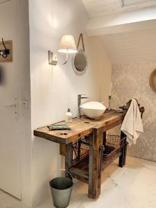 ein Badezimmer mit einem Waschbecken auf einem Holztisch in der Unterkunft VILLA NOTRE DAME face au Château fort in Sedan