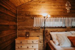 1 dormitorio con cama, lámpara y cómoda en Romantické ubytovanie pre dvoch v lese, en Banská Bystrica