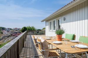 una terrazza in legno con tavolo e sedie. di Family home near the ocean, with large patio & BBQ a Skärhamn