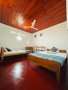 ゴールにあるUma Beach Homeの木製天井のドミトリールームのベッド2台分です。