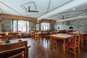 uma sala de jantar com mesas e cadeiras de madeira em Hotel Tulsi em Pokhara