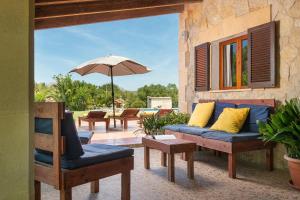 a patio with a couch and chairs and an umbrella at Villa Lucas - Pollença in Pollença