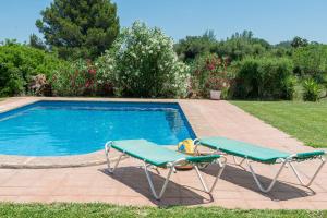 a swimming pool with two lounge chairs next to it at Villa Lucas in Pollença