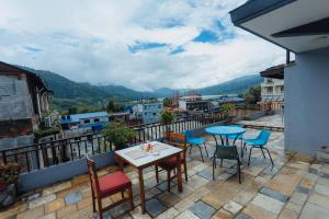 uma mesa e cadeiras em uma varanda com vista em Hotel Tulsi em Pokhara