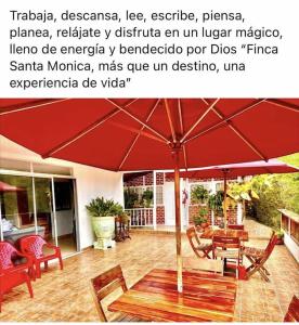 - un parasol rouge assis au-dessus d'une terrasse dans l'établissement Finca Santa Monica Guatape Privada Lujosa Piscina Jacuzzi Sauna muelle Represa jetski planchon, à Guatapé