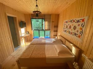 2 łóżka w pokoju z drewnianymi ścianami w obiekcie Chateau Chao w mieście Khulo
