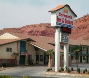 ein Gebäude mit einem Schild für ein Gasthaus und Suiten in der Unterkunft Coronada Inn & Suites in St. George