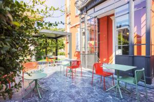 a patio with tables and chairs outside a building at Villa Rossella in Locarno