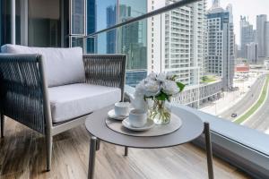 a living room with a chair and a table and a window at Lusso Hometels J One Business Bay in Dubai