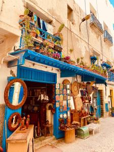 a blue building with a shop in the street at Dar Farah, riad au coeur de la médina in Essaouira