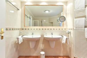 un bagno con due lavandini e un grande specchio di Zur Alten Gärtnerei a Westerland