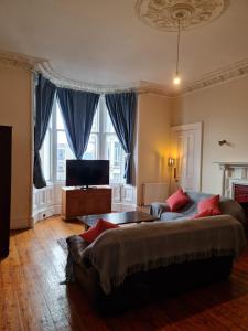 een woonkamer met een bank en een flatscreen-tv bij Apex Haymarket Station Apartment in Edinburgh