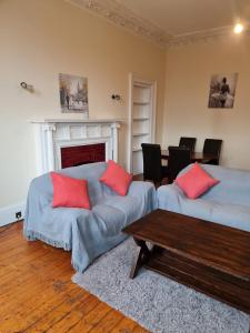 een woonkamer met 2 bedden en een tafel bij Apex Haymarket Station Apartment in Edinburgh