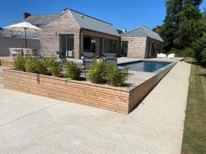 einen Hinterhof mit einem Pool und einem Haus in der Unterkunft Magnifique villa avec piscine, à 5 min des plages in Landunvez