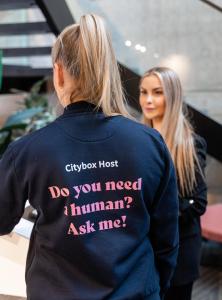 a woman wearing a shirt that says do you need a human ask me at Citybox Oslo in Oslo